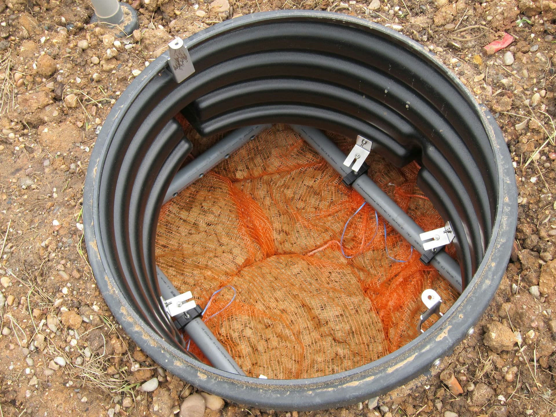 The view in the top of the BIOROCK unit, showing the grey effluent delivery pipes and the foam media inside orange string bags